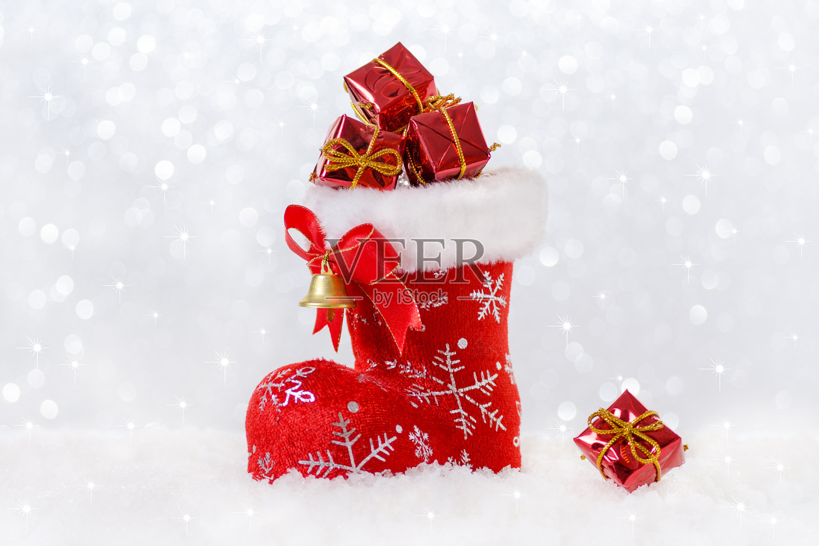 红色的圣诞袜配着礼物，圣诞老人的靴子在雪地里照片摄影图片