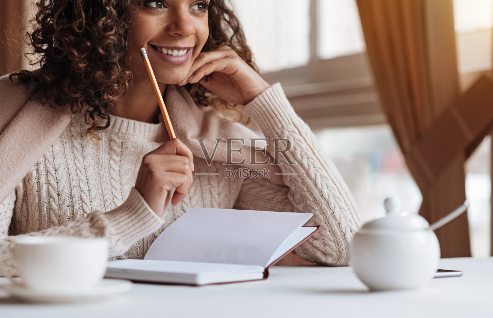 一个积极的非裔美国女人在咖啡馆做笔记照片摄影图片