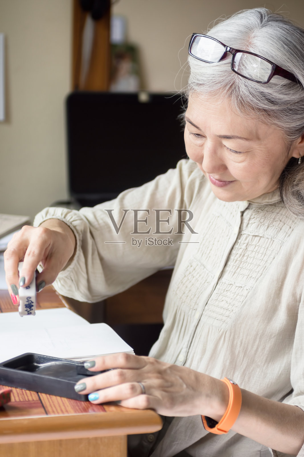 亚洲年长女性艺术家使用Suiteki和sudzuri照片摄影图片