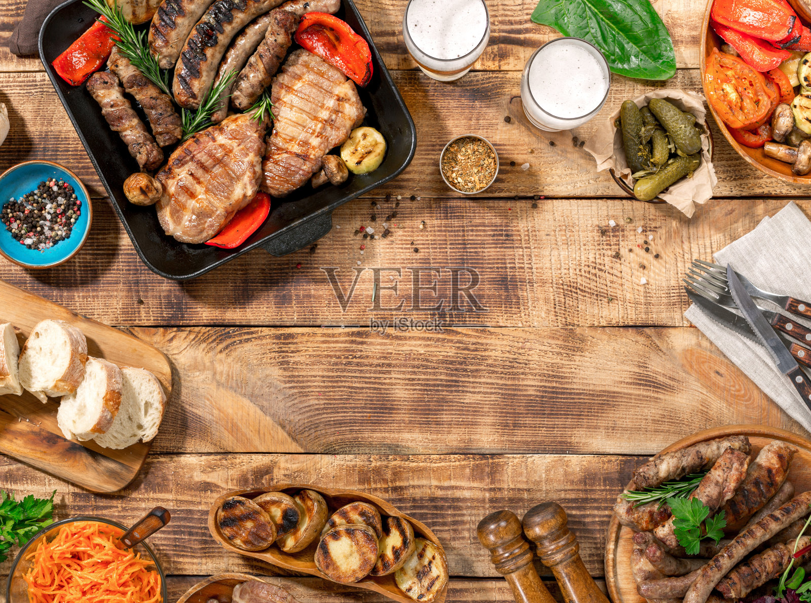 开胃的烧烤牛排，香肠和烤蔬菜在一个木制的野餐桌上复印空间照片摄影图片