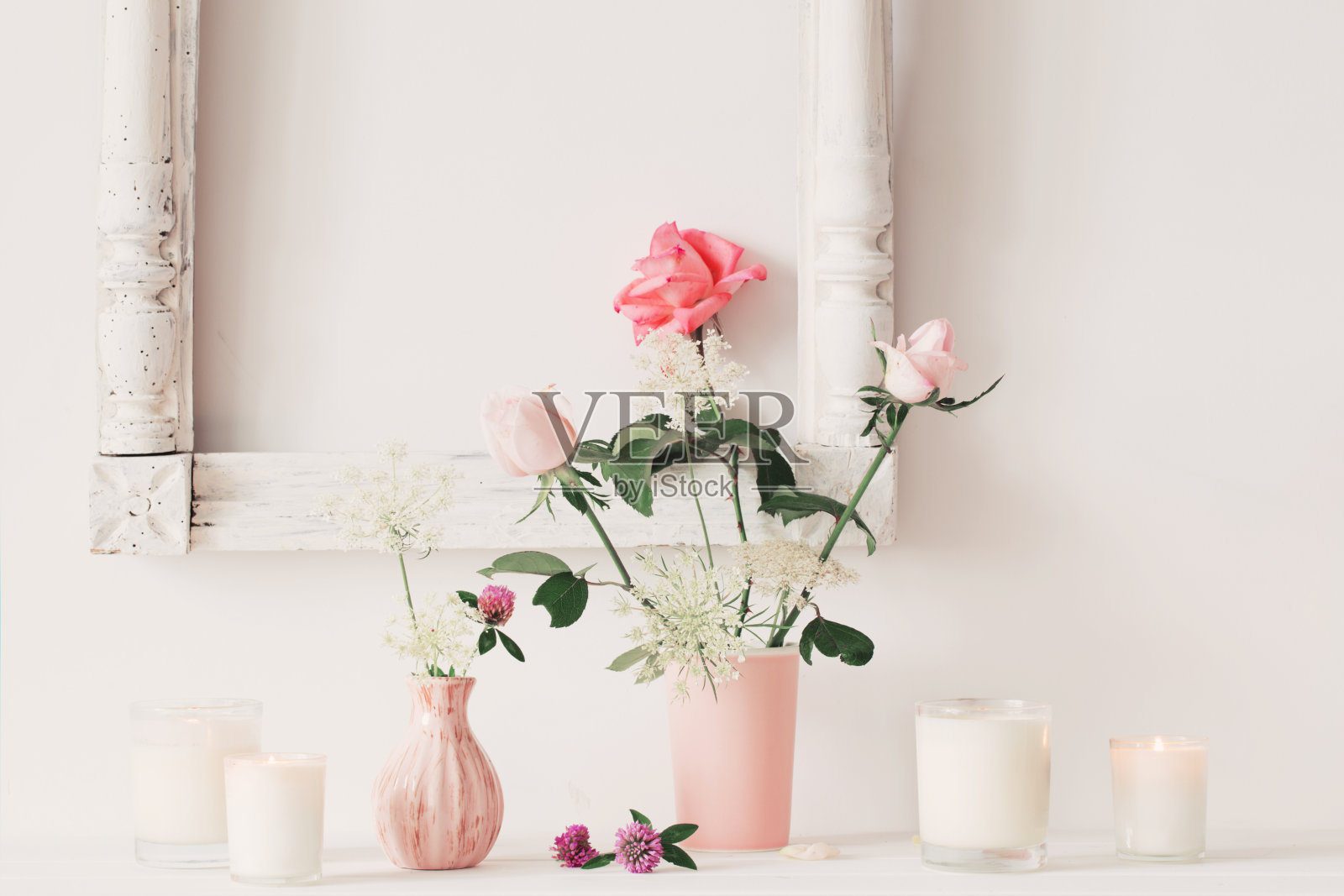 花瓶上插着花，白色背景上插着蜡烛照片摄影图片