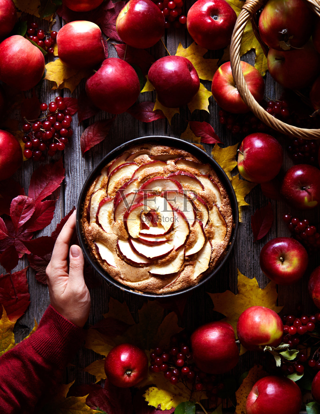 苹果派蛋糕用切片装饰在烤盘上，以木为背景的红苹果。照片摄影图片