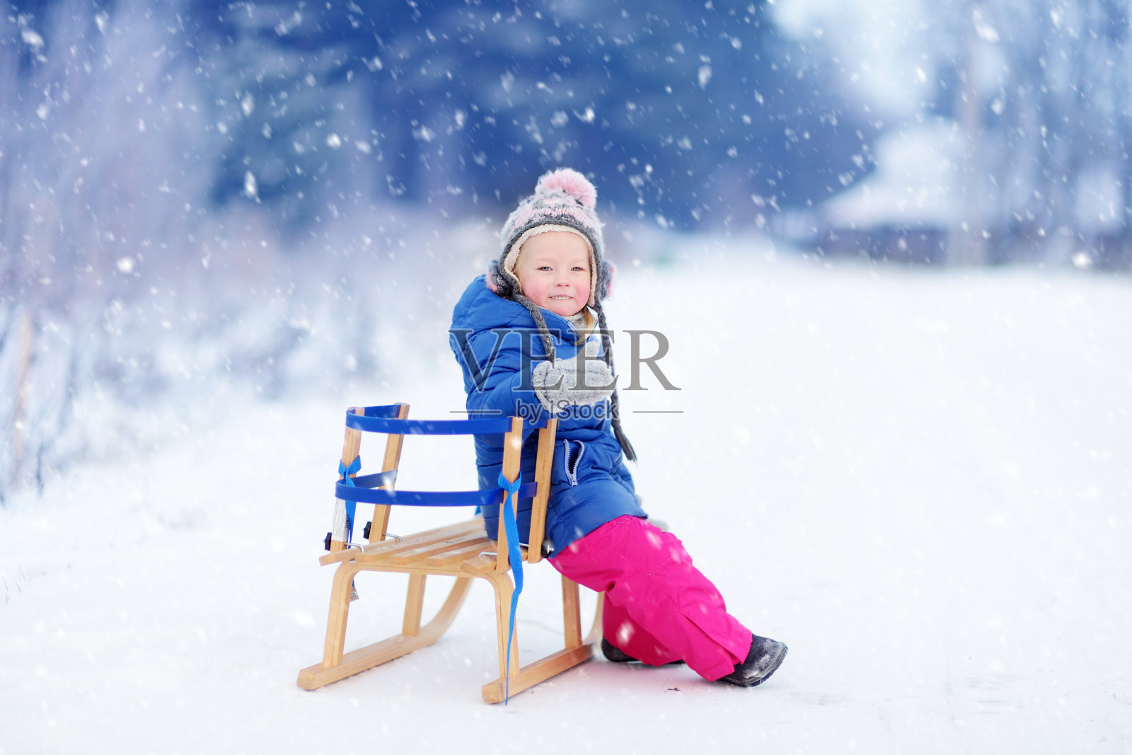 有趣的小女孩在冬季公园玩雪橇照片摄影图片