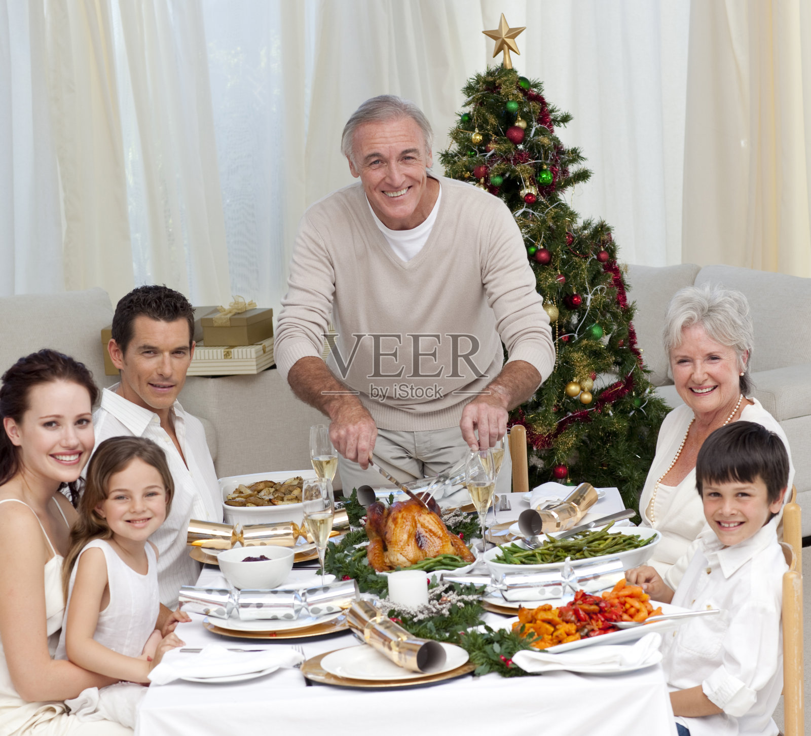 爷爷正在切圣诞晚餐用的火鸡照片摄影图片