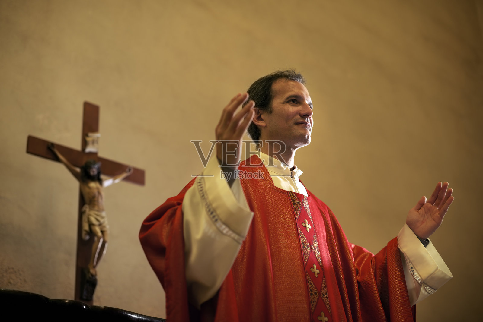 在弥撒期间在祭坛上祈祷的天主教牧师照片摄影图片
