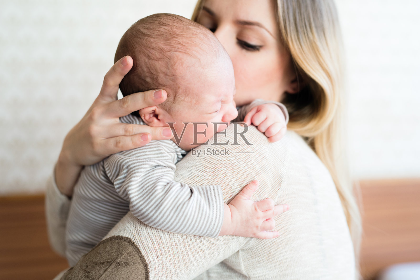 年轻漂亮的母亲抱着她的儿子照片摄影图片