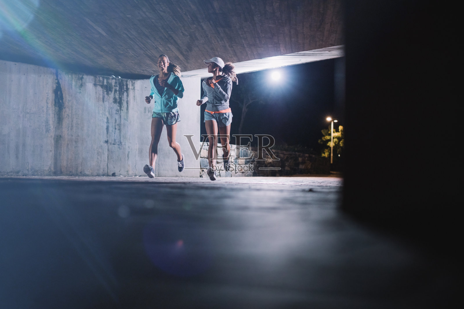 两个年轻女人晚上在城里慢跑照片摄影图片