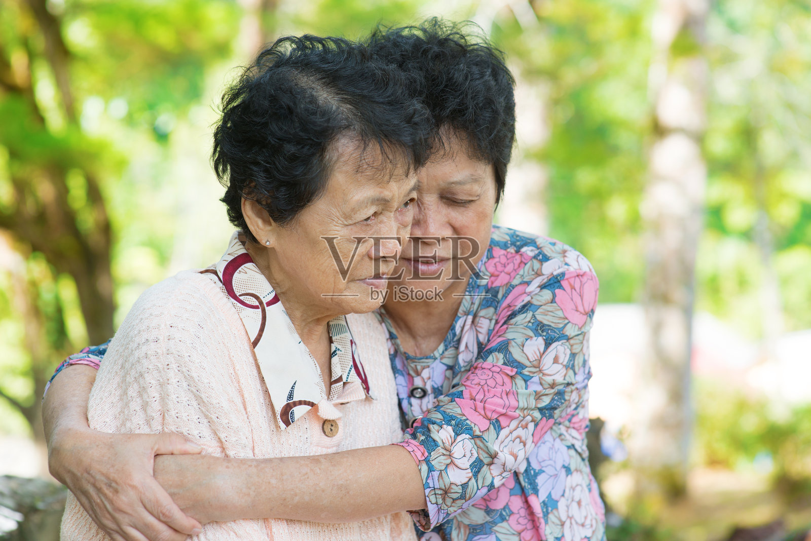 亚洲成熟女人拥抱和安慰她哭泣的老母亲照片摄影图片