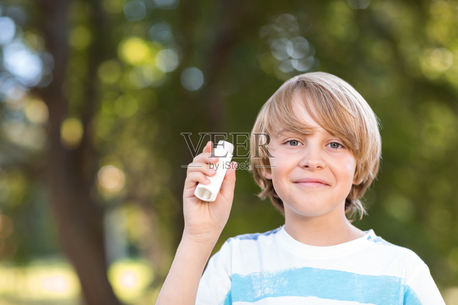 小男孩在用他的吸入器照片摄影图片