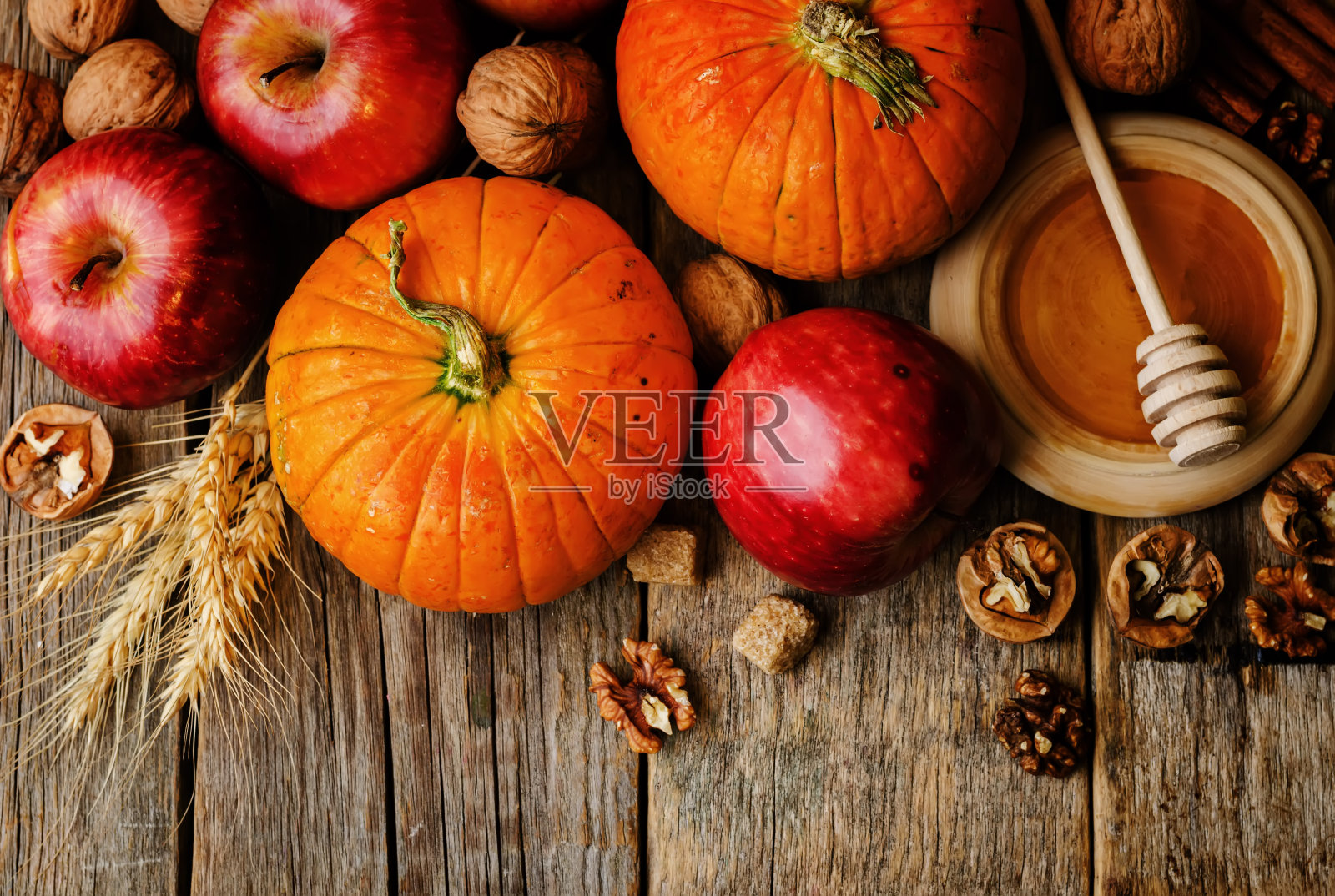 木材背景与南瓜，苹果，小麦，蜂蜜和坚果照片摄影图片