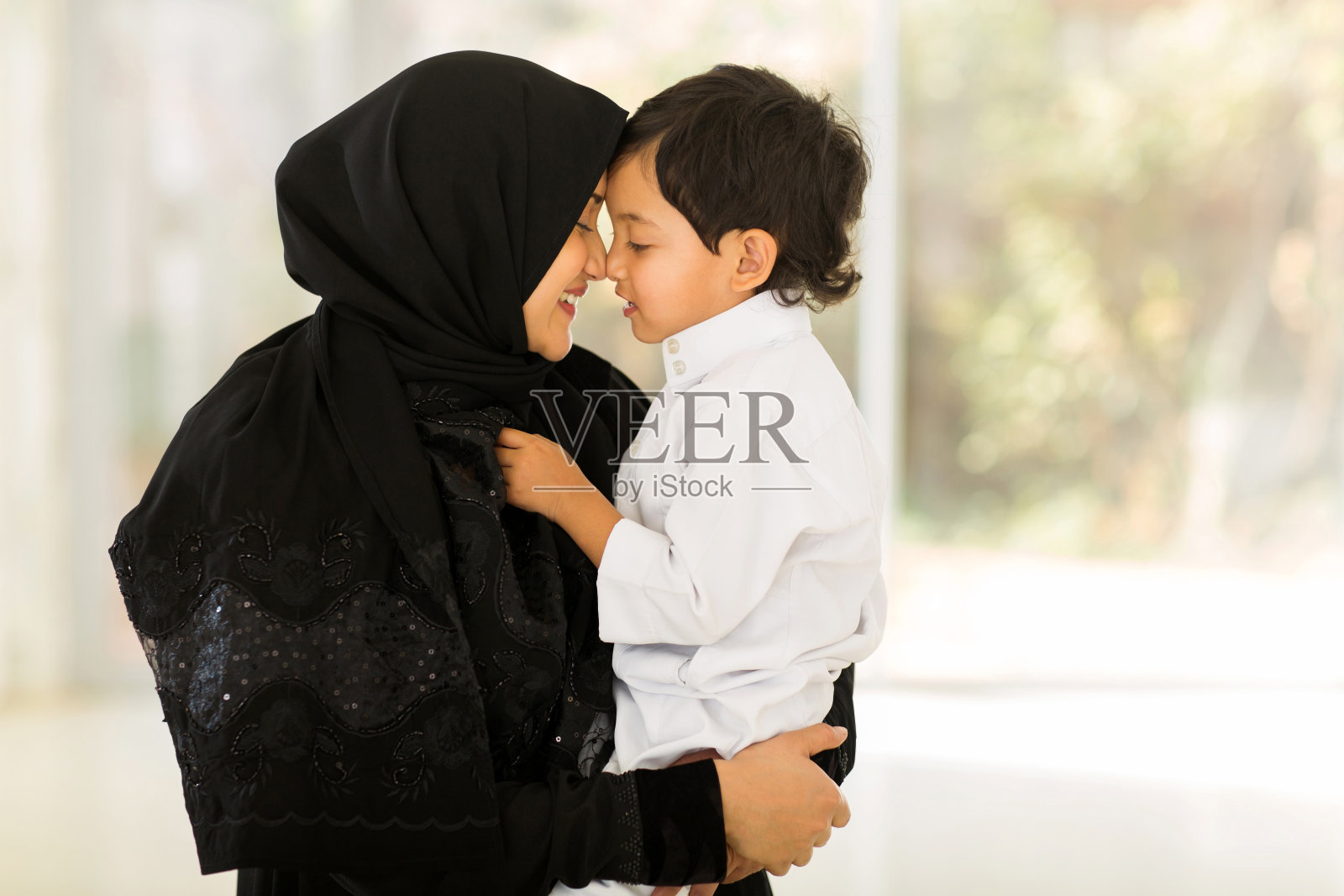 一位中东妇女和她的儿子玩照片摄影图片