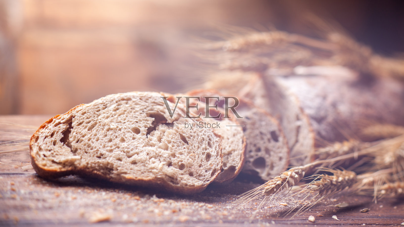 面包和小麦放在木桌上，浅DOF照片摄影图片