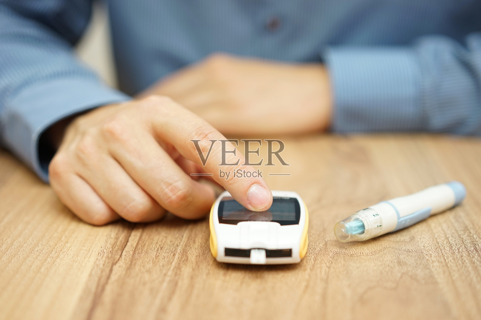 男人用数字血糖仪检测血糖水平，糖尿病治疗照片摄影图片
