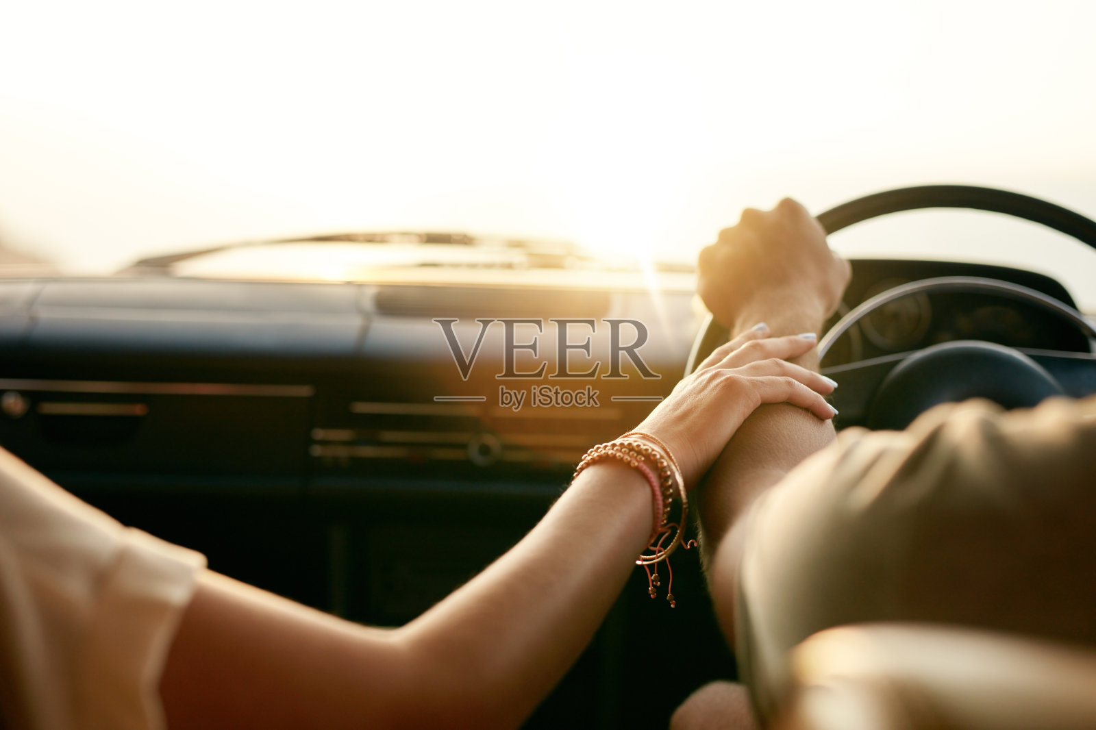 年轻夫妇手牵着手坐在车里照片摄影图片