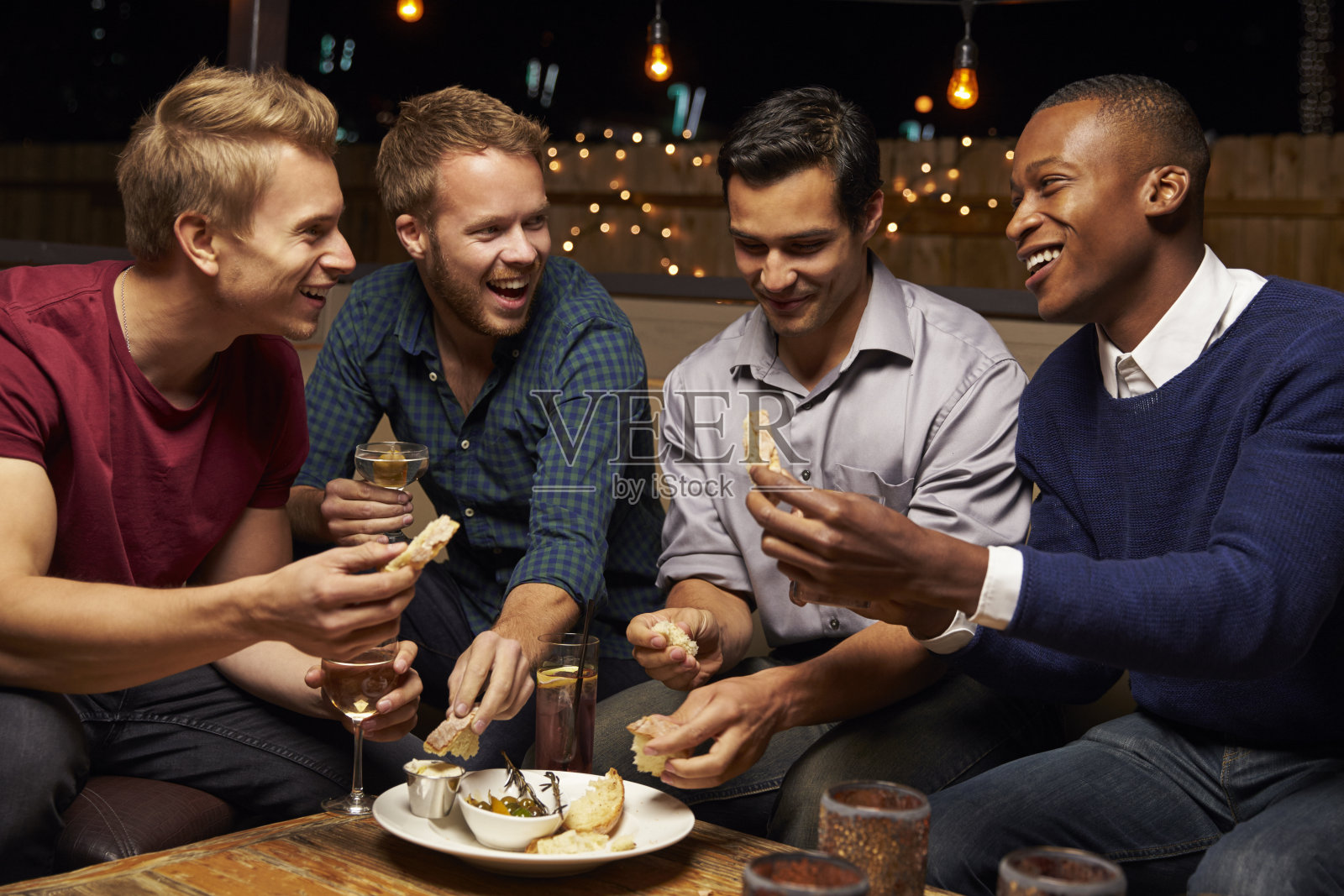 一群男性朋友在屋顶酒吧享受夜晚照片摄影图片