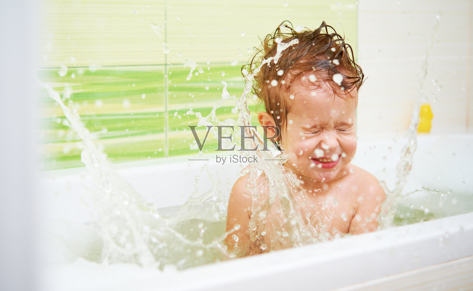 快乐的宝宝在浴缸里洒水嬉戏照片摄影图片
