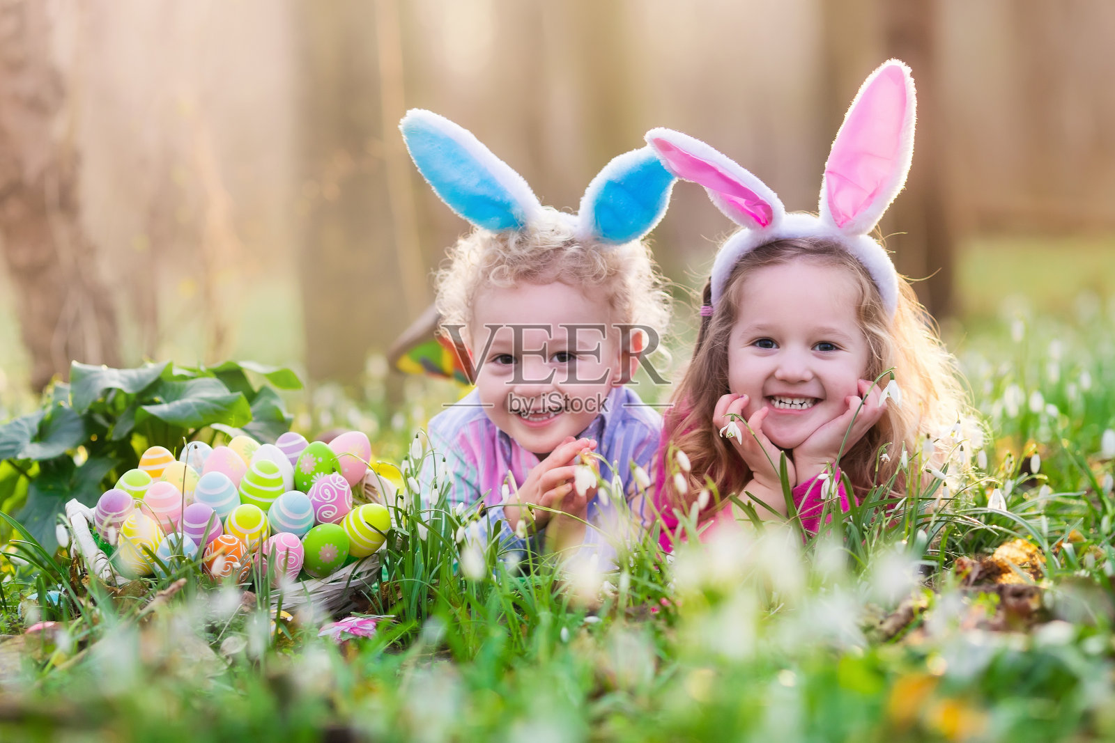 孩子们在春天的花园里寻找复活节彩蛋照片摄影图片