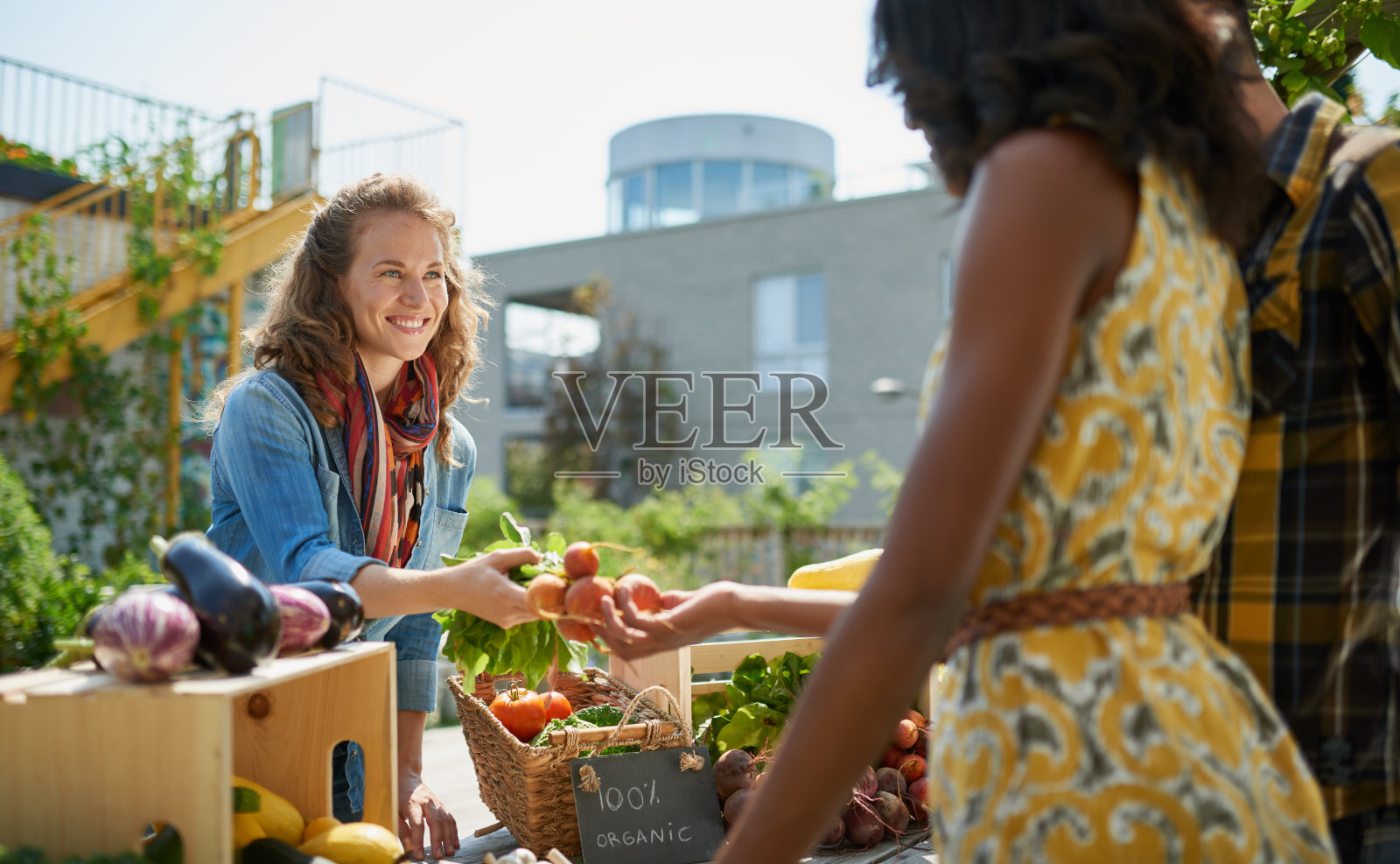 友好的女人在一个农民的有机蔬菜摊上照片摄影图片