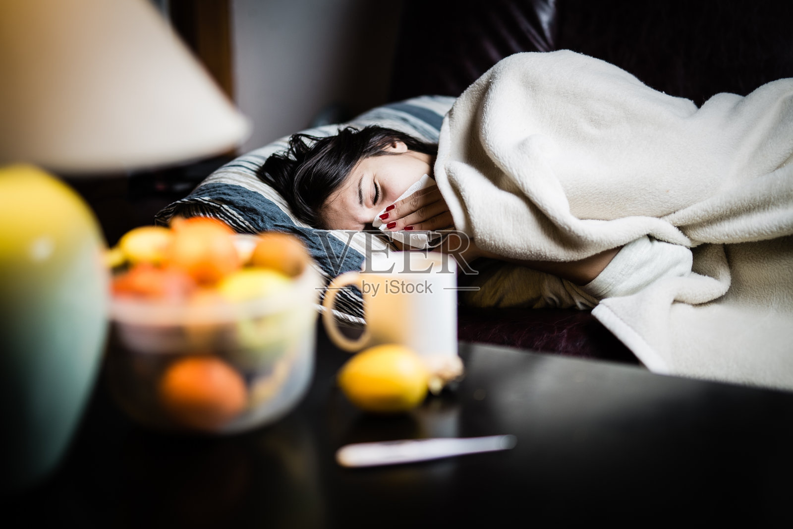 流感。女人感冒了病毒生病的女人躺在床上盖着羊毛毯子照片摄影图片