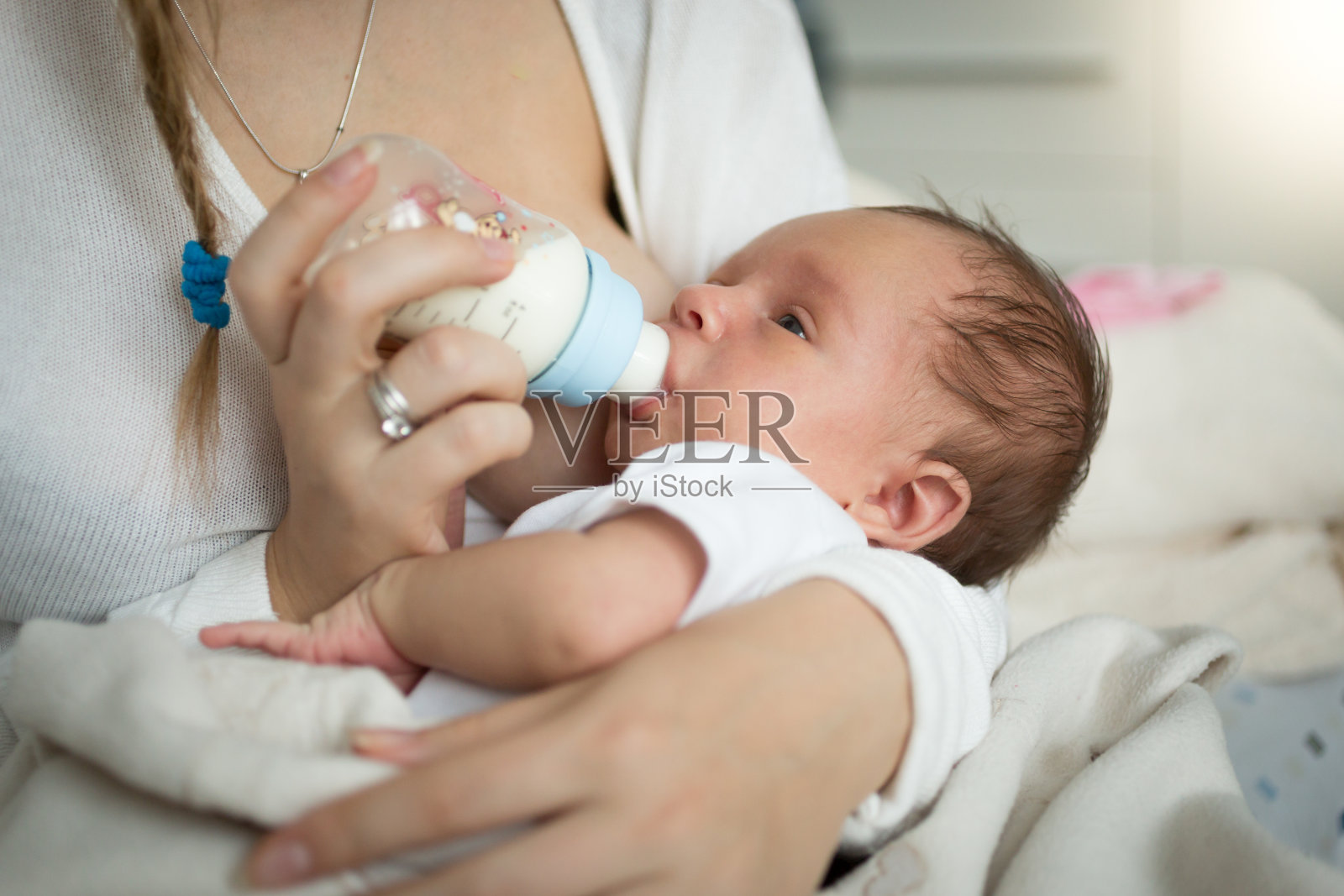 母亲从奶瓶喂养新生儿的特写照片摄影图片