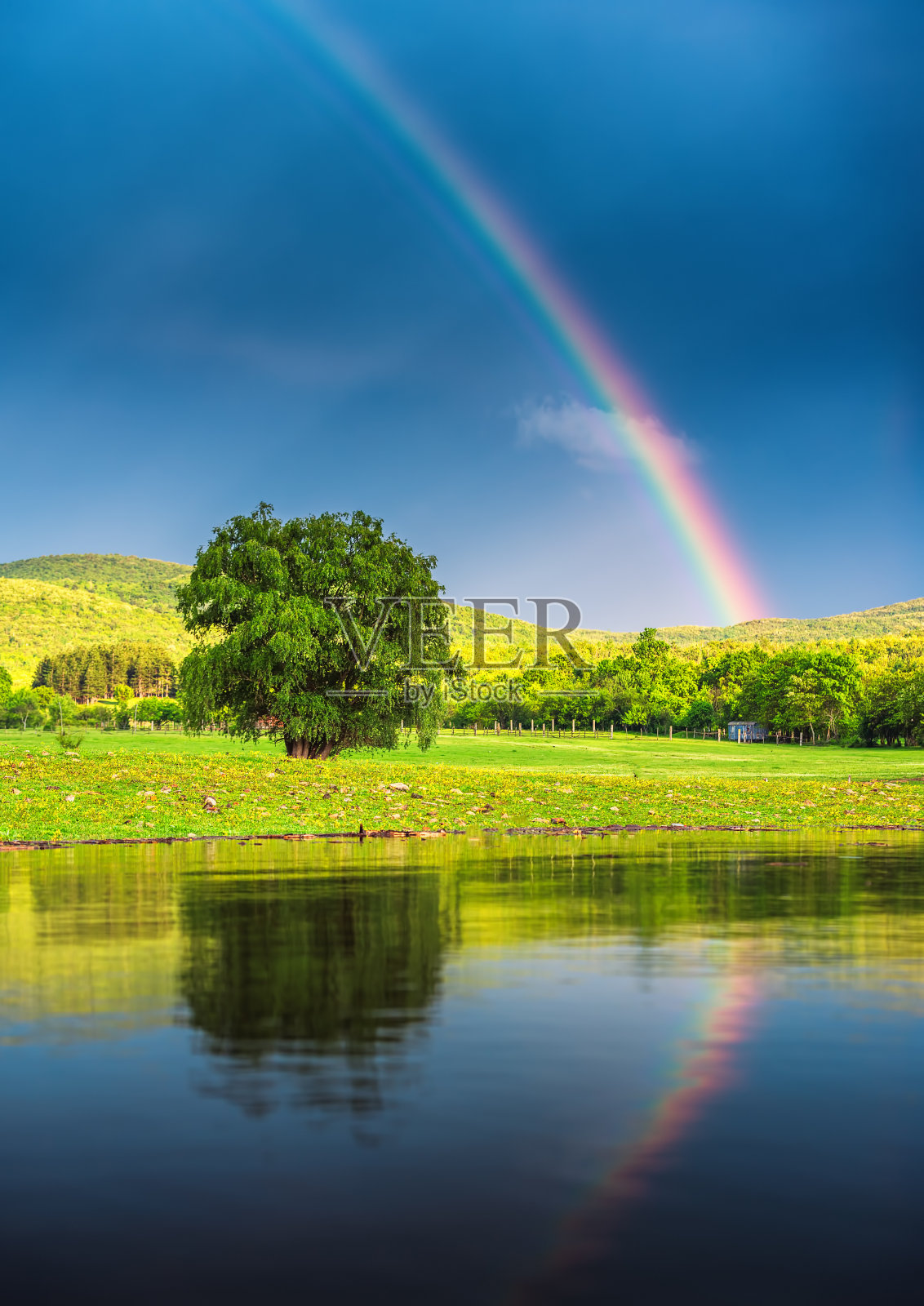 湖面上的彩虹，倒映在水面上照片摄影图片