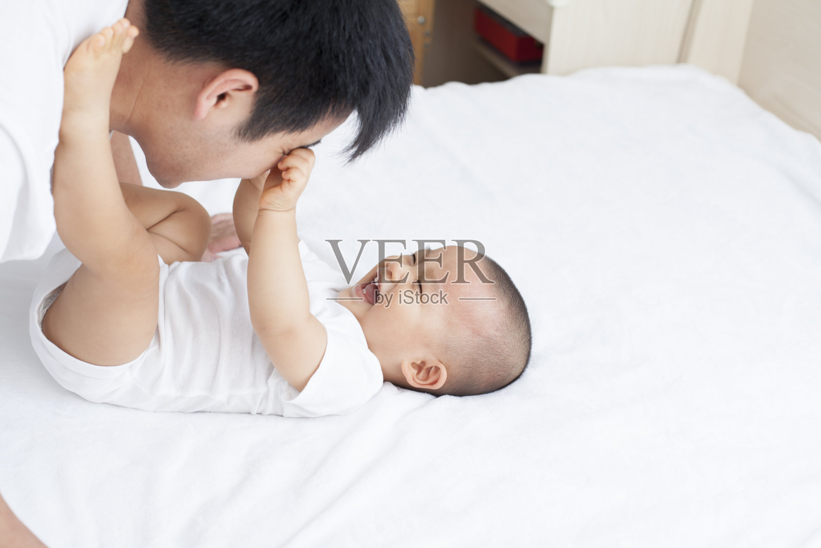 中国父亲和儿子在床上玩照片摄影图片