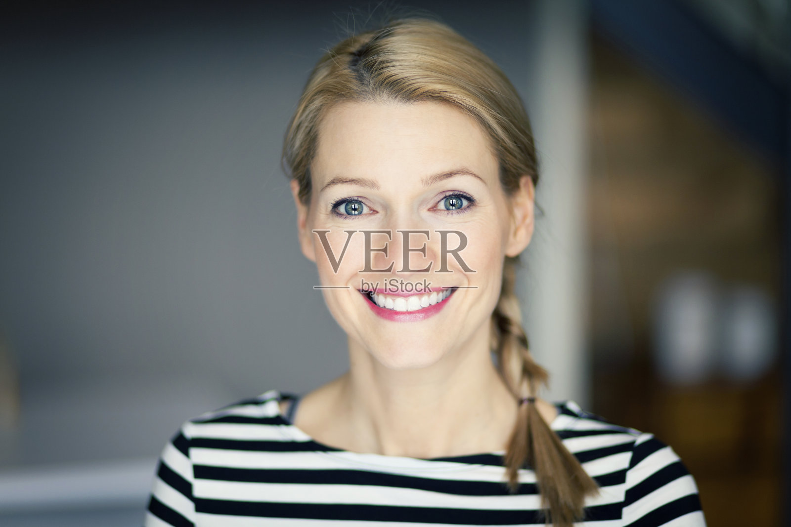 一个微笑的金发女人穿着条纹衬衫的特写照片摄影图片