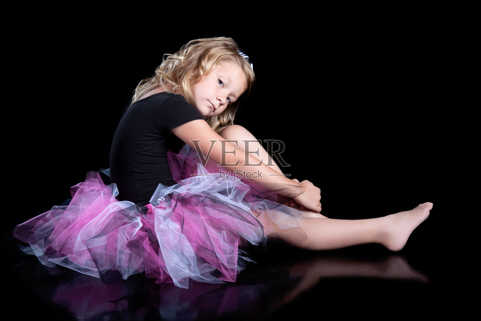 黑色背景下微笑的小女孩穿着芭蕾舞裙照片摄影图片