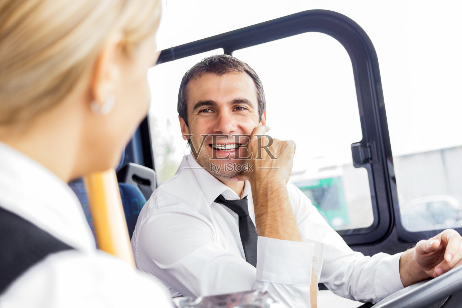 巴士司机在和乘客说话。照片摄影图片