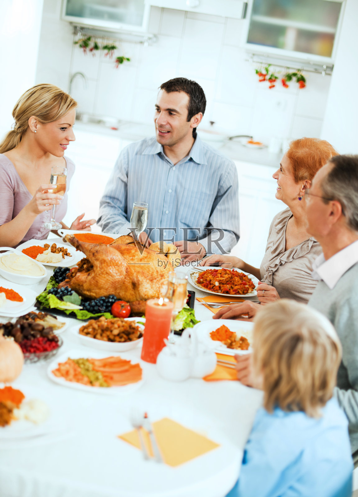 感恩节一家人围坐在餐桌旁。照片摄影图片