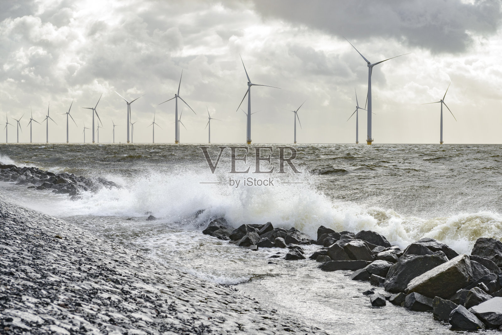 风暴中陆地和近海的风力涡轮机照片摄影图片