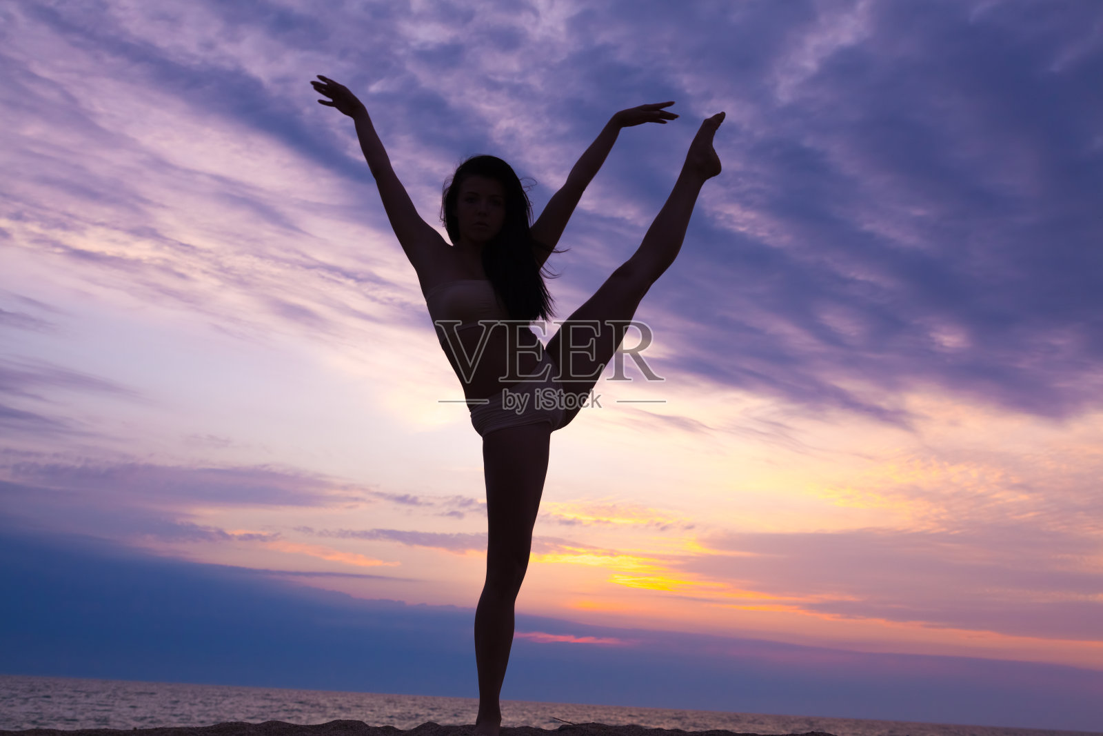 现代现代舞年轻女子体操运动员在日落海滩照片摄影图片