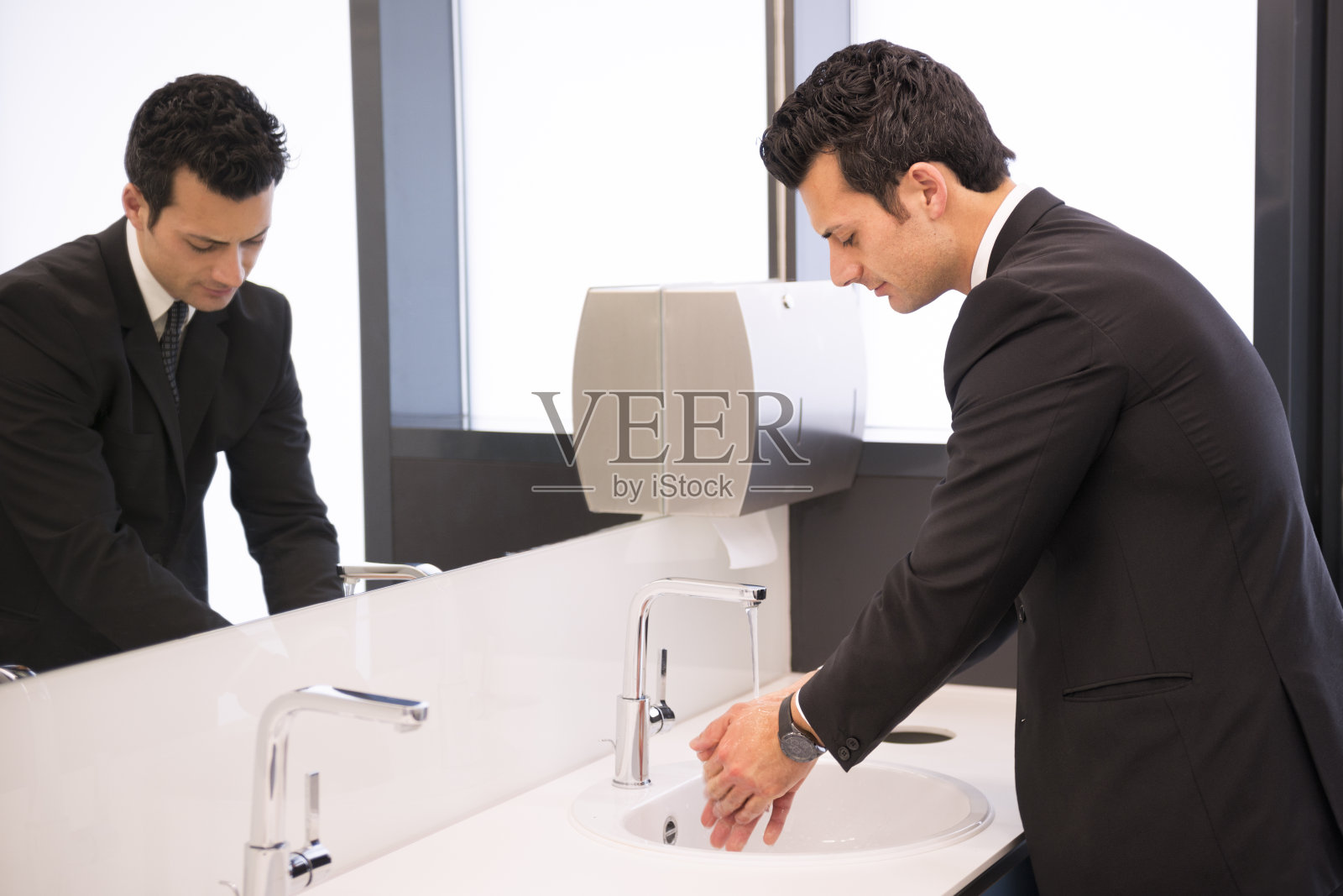 商人在厕所洗手照片摄影图片