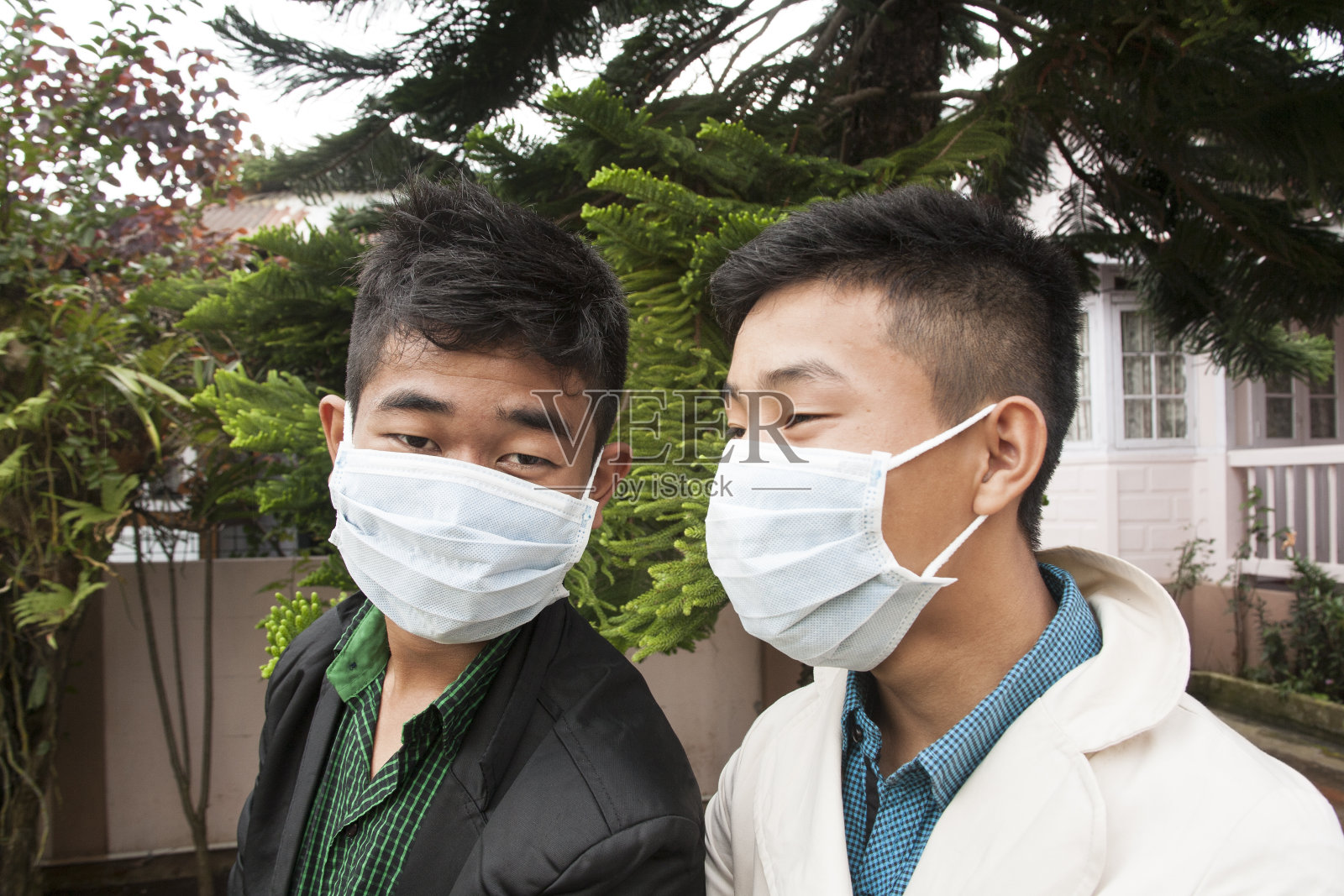 亚洲人，年轻的成年男子在户外戴着防护口罩。照片摄影图片