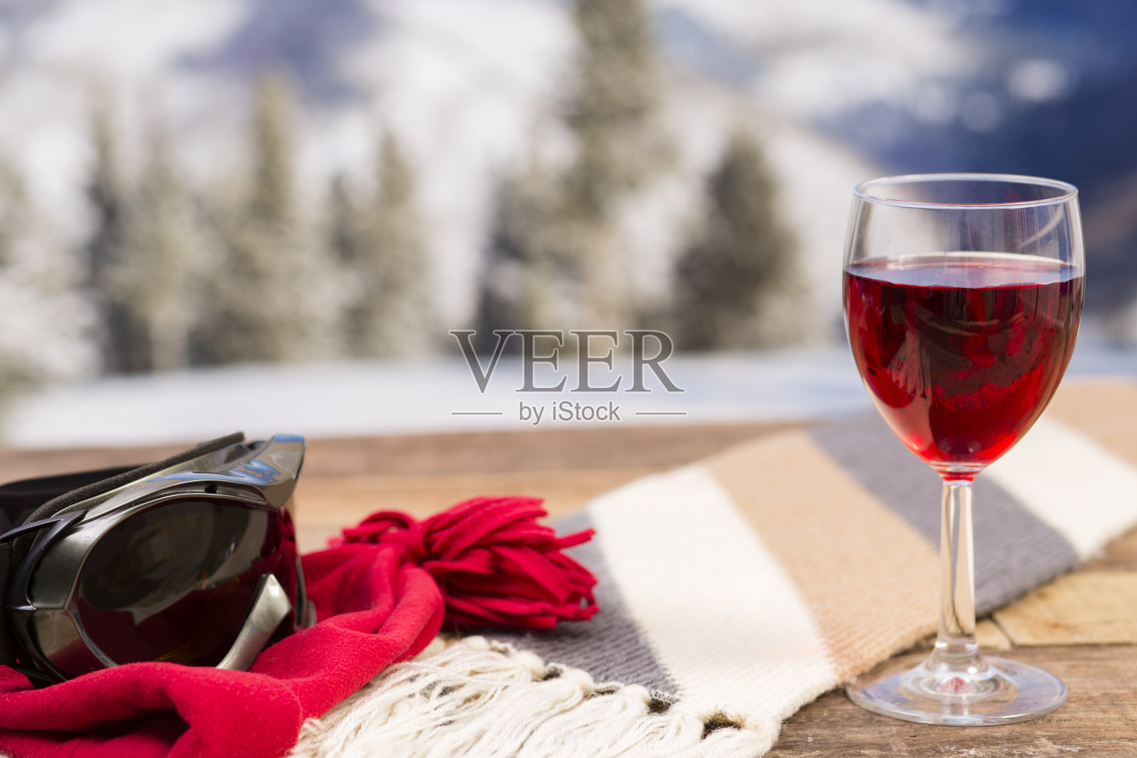 红酒，滑雪镜和冬天的山脉背景。照片摄影图片