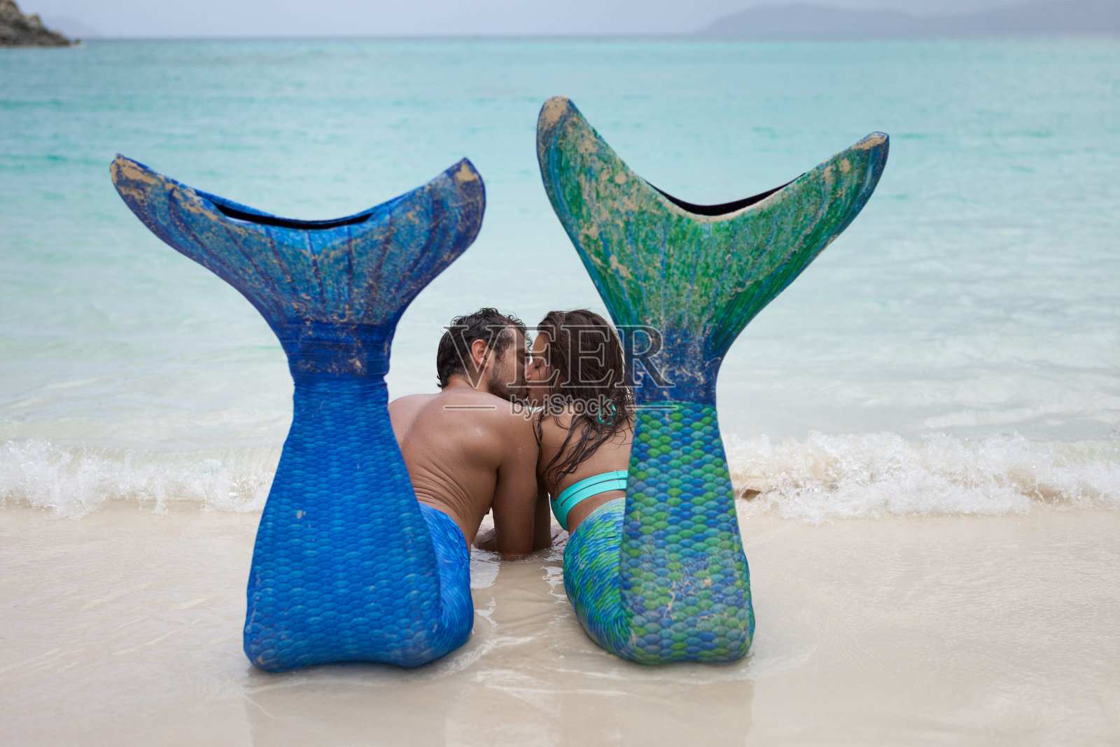 一对美人鱼夫妇在加勒比海的热带海滩上休息照片摄影图片