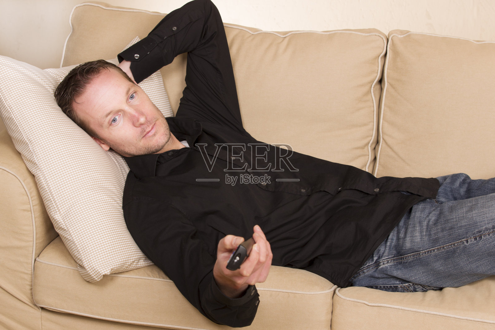 一个男人懒洋洋地躺在沙发上照片摄影图片