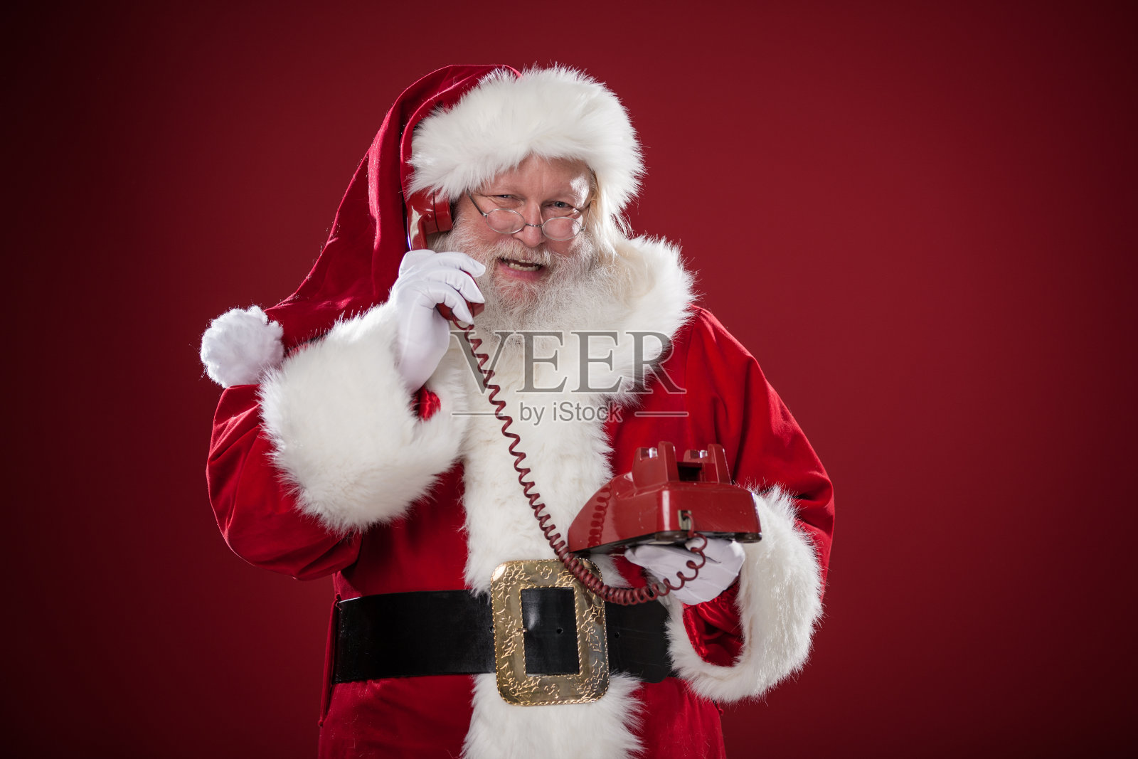 真正的圣诞老人在旋转电话上交谈照片摄影图片