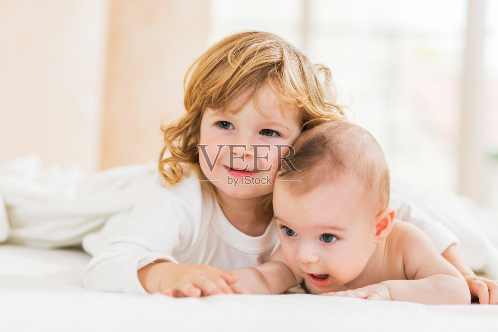 快乐的家庭妈妈和宝宝在床上玩耍和拥抱照片摄影图片_ID:141214764-Veer图库