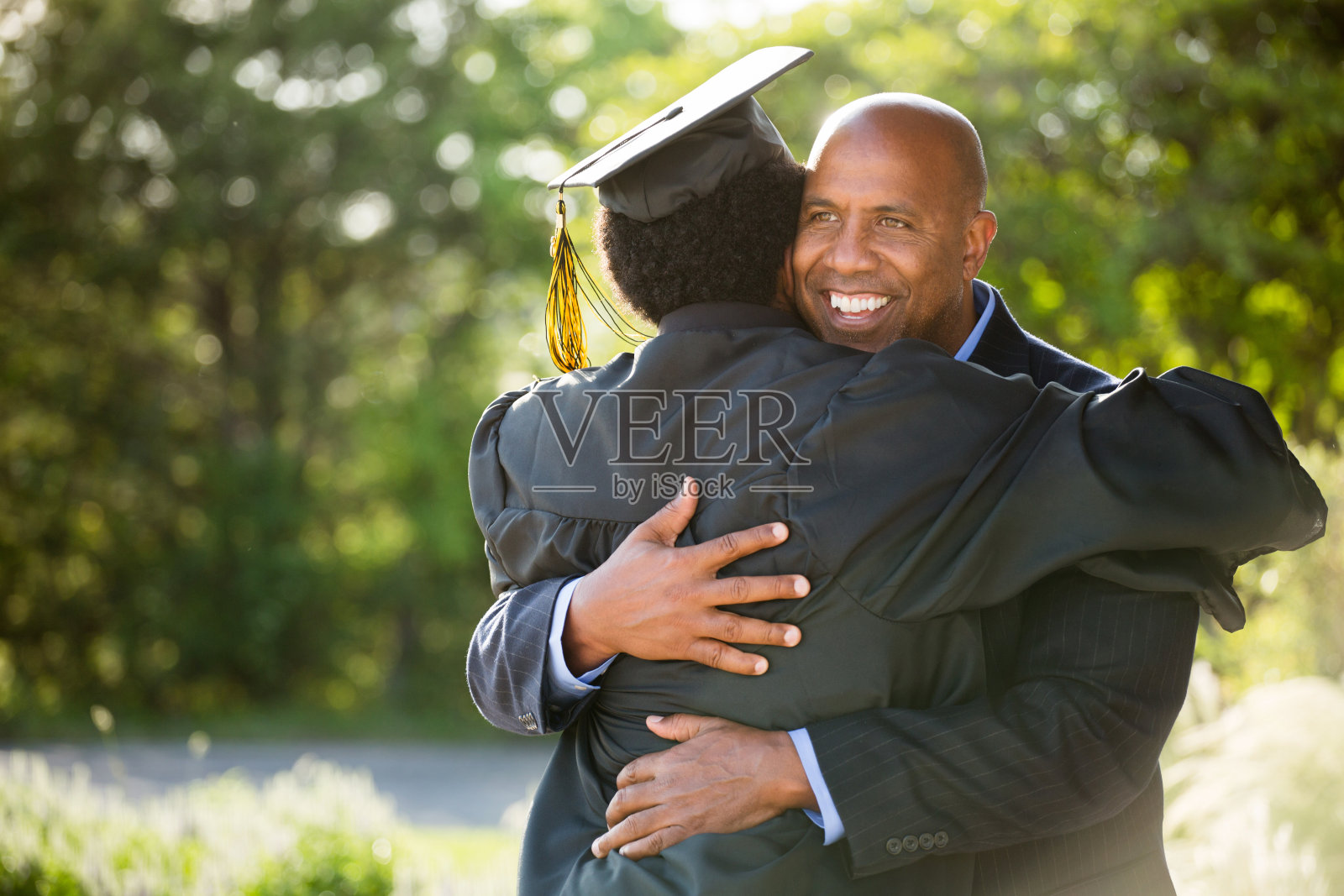 非裔美国人父亲和儿子在毕业典礼上照片摄影图片