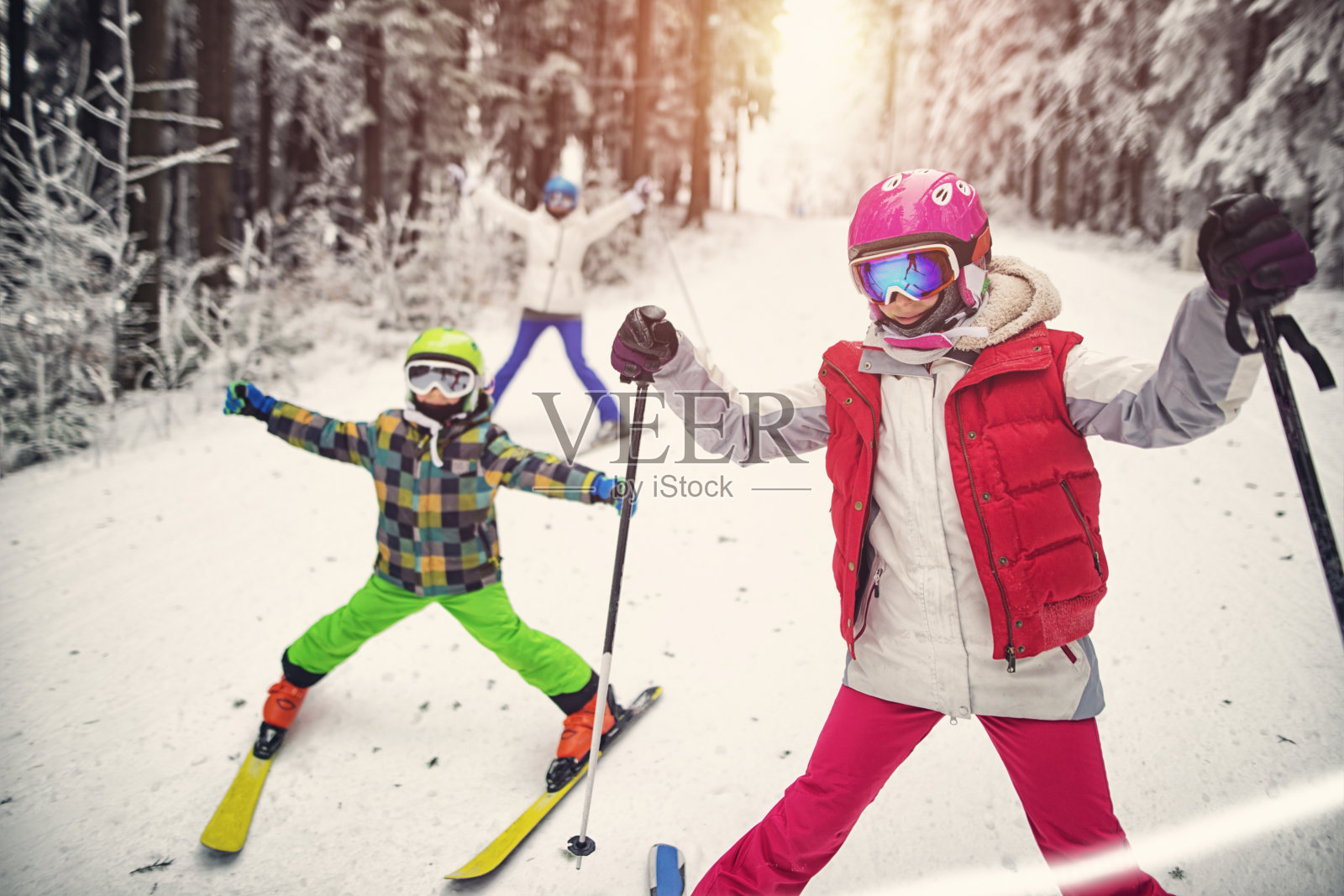 母亲和孩子有乐趣滑雪在冬天的一天照片摄影图片