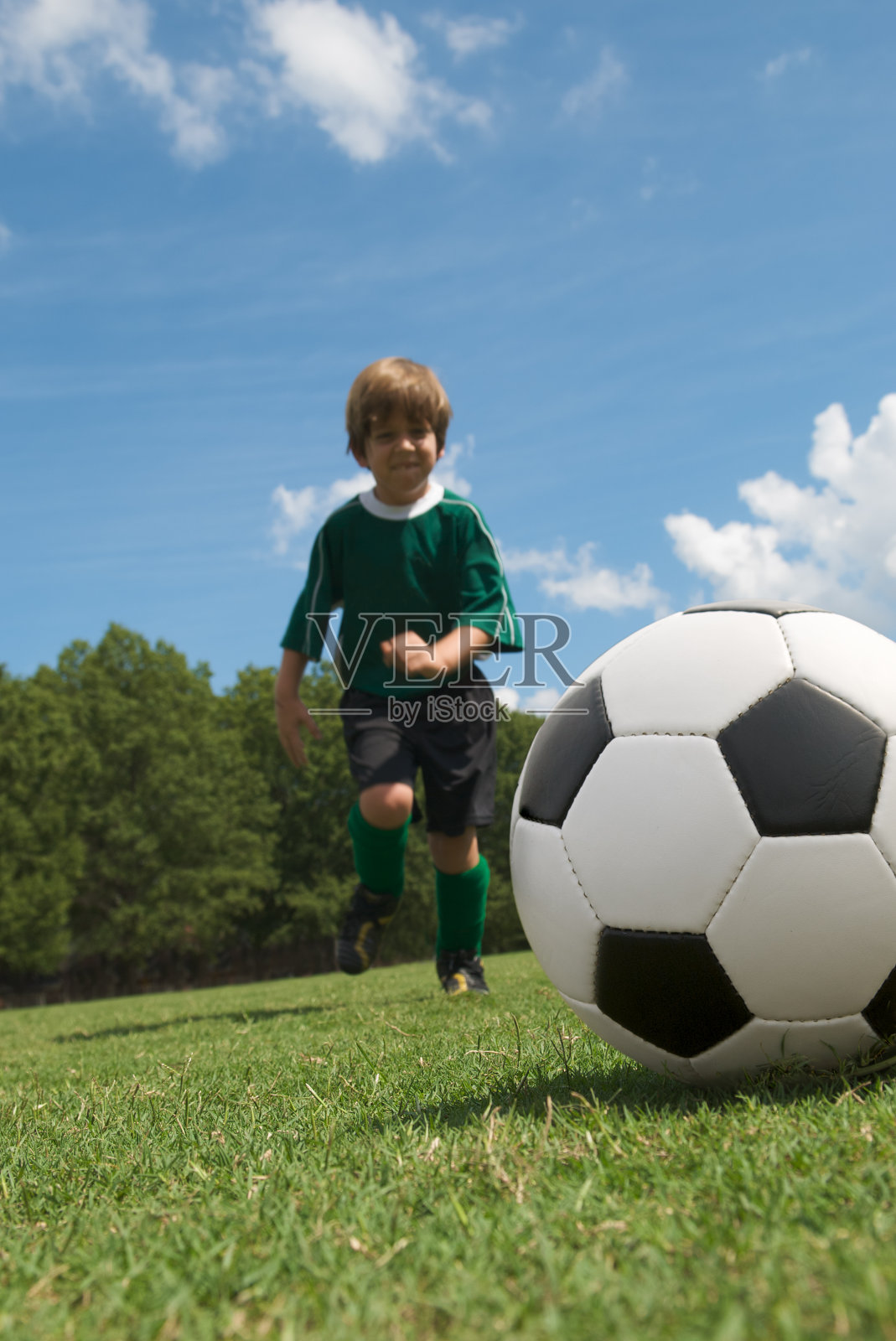 男孩跑向足球照片摄影图片