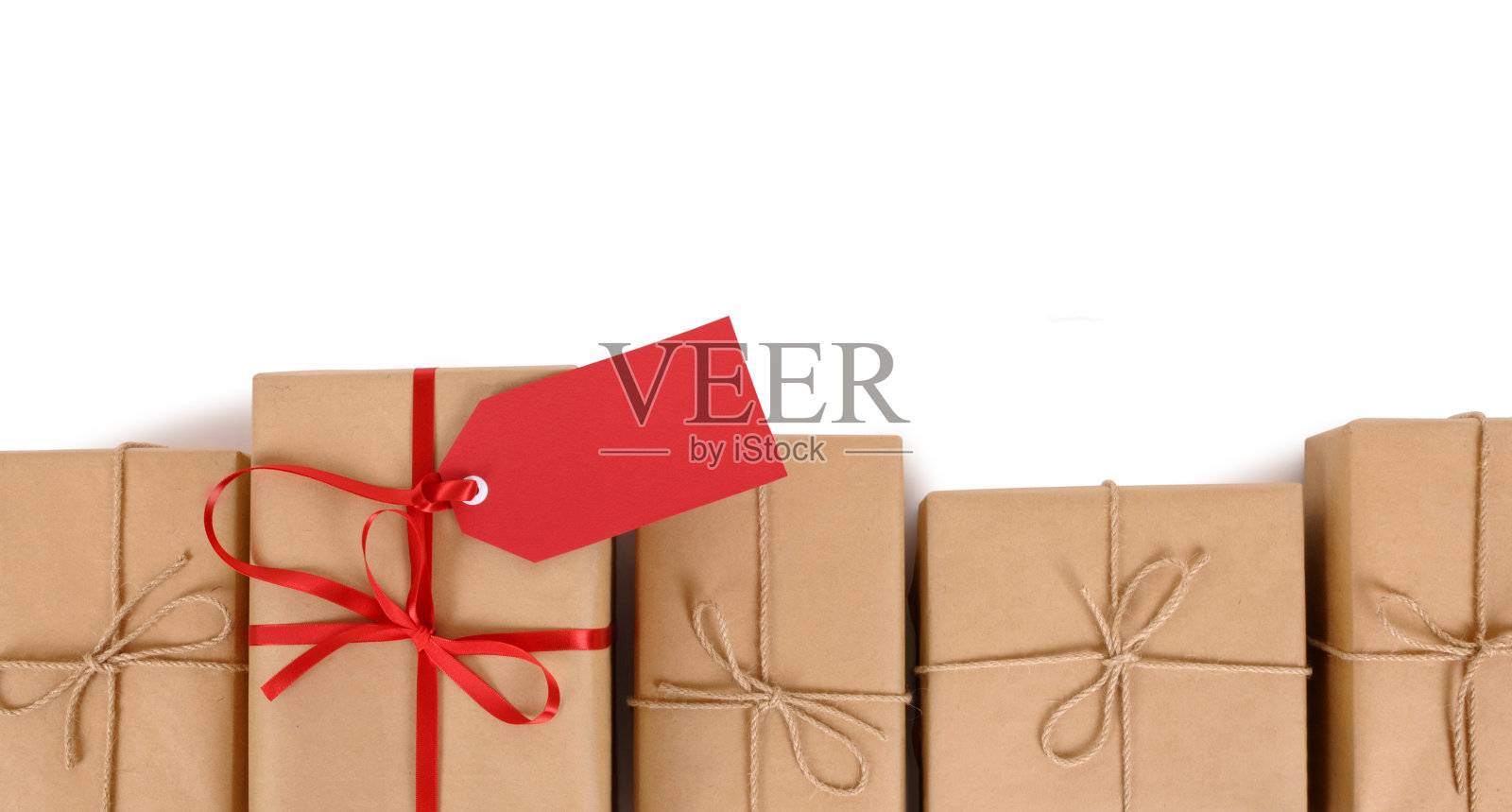 棕色的纸包装，红色的礼品标签在一排普通的照片摄影图片