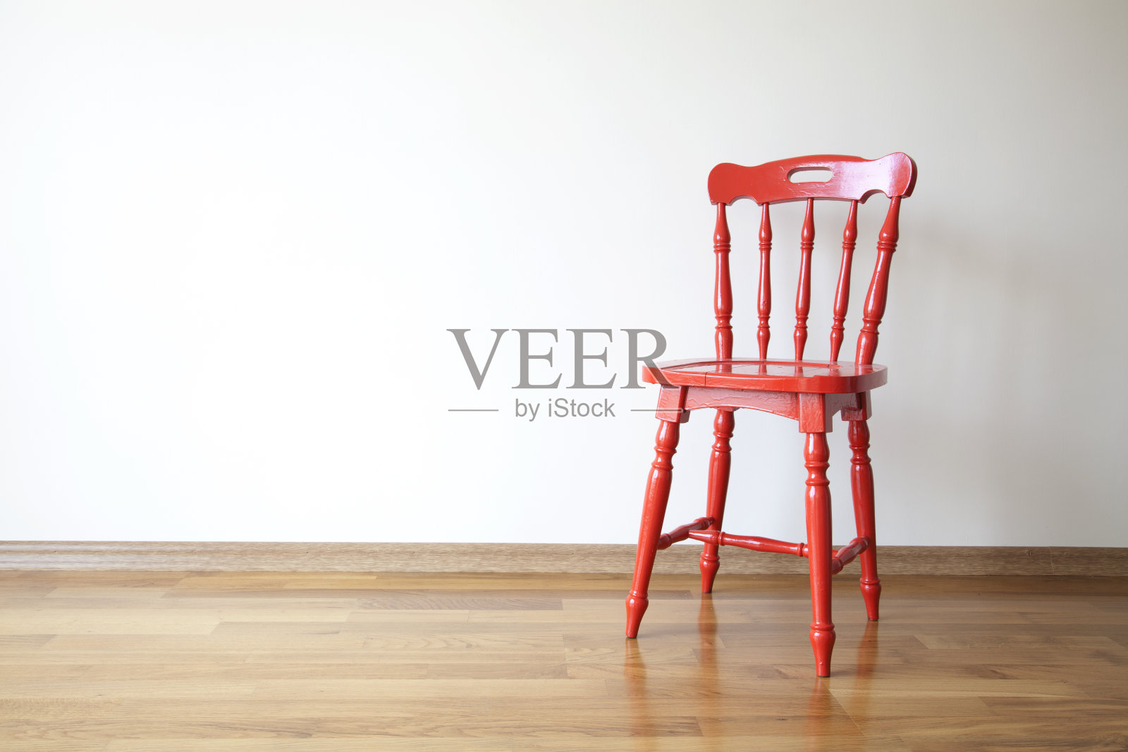 一张空白墙前的红色木椅的照片照片摄影图片