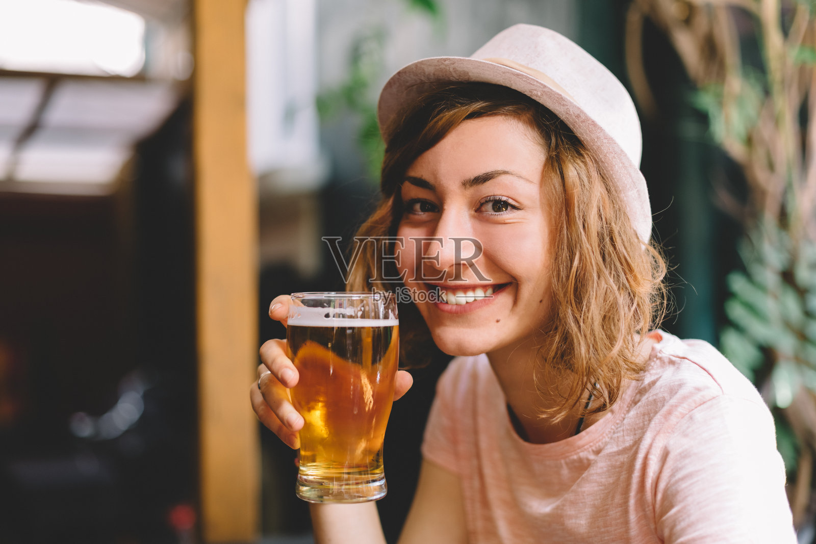 微笑的女人拿着一品脱啤酒照片摄影图片