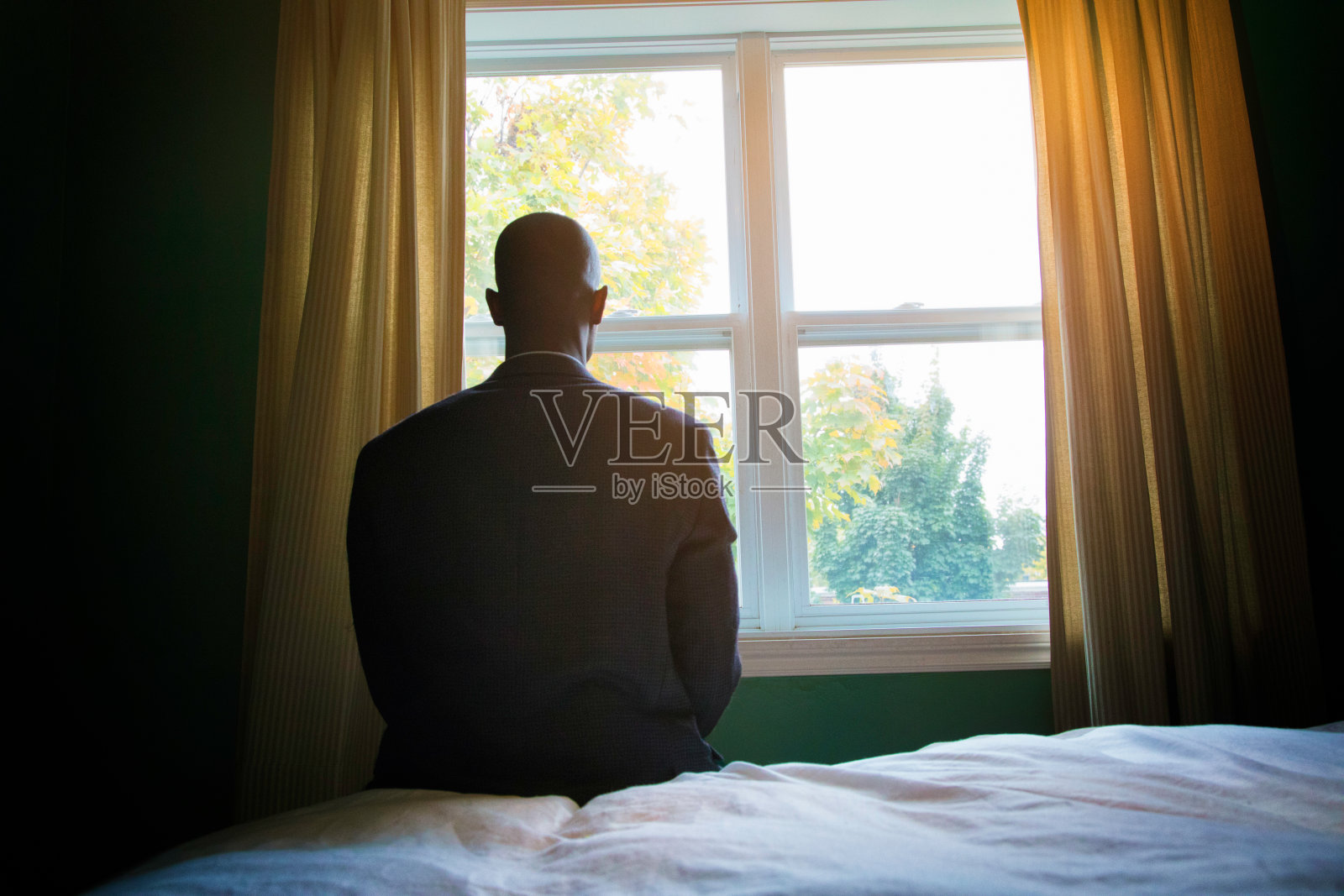 穿着西装在窗前祈祷的单身男子照片摄影图片