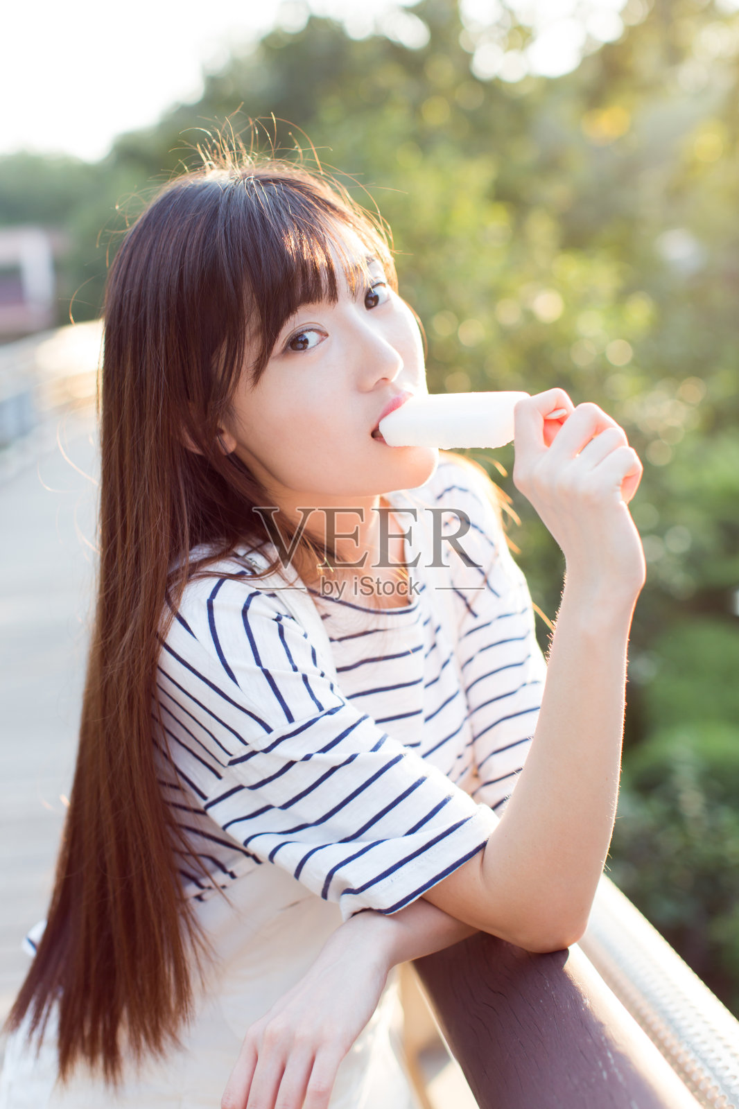 年轻美丽的女人在大自然中吃着美味的冰淇淋照片摄影图片