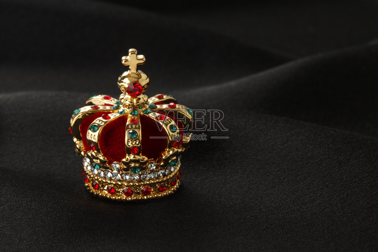 金色的皇冠上镶嵌着绿色和红色的宝石照片摄影图片