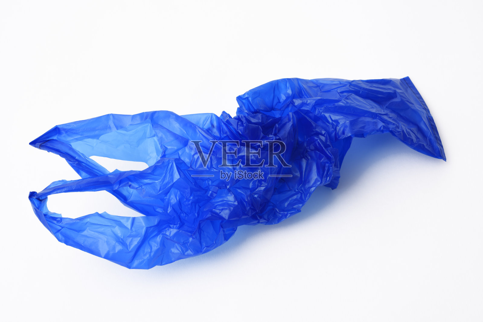 白色背景上皱巴巴的蓝色塑料购物袋照片摄影图片