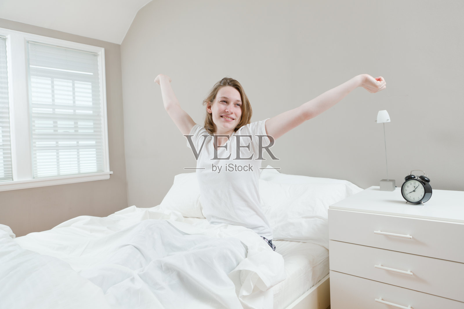 美丽快乐的年轻女子坐在床上醒来照片摄影图片_ID:316011099-Veer图库